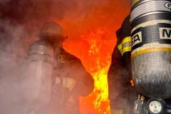 Firefighter directing hose at structure — kitchen fire May 2024