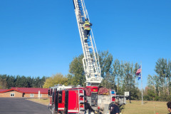 Red fire truck with extended ladder — fire prevention October 2024