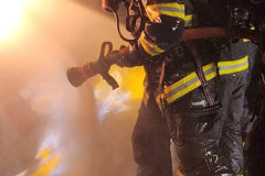 Firefighter in full gear actively fighting fire — propane burn training November 2025