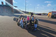 Group on airport tarmac next to aircraft — fire prevention Moose Lake School 2022