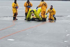 Rescue workers in yellow suits gathered on ice — ice rescue training 2023