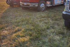 Grassy field with parked vehicles — County Road 11 wildland fire 2023
