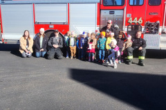 Children and adults gathered in front of fire truck — fire prevention 2025