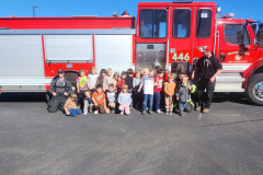 Children posing in front of fire truck — fire prevention 2025