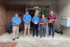 Six people in blue uniforms standing in brick-walled room — EMS Unit of the Year 2024