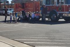 Red fire truck on street with people standing beside it — fire prevention 2020