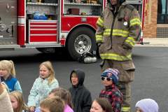Children watching firefighters in full gear — fire prevention 2023