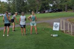 Four people on grassy field — golf scramble fundraiser 2023