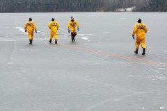 Four people in yellow jackets on frozen lake — ice rescue training 2023
