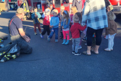 Young children gathered on blue surface — fire prevention October 2024