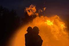 Silhouetted couple against large fire backdrop — propane emergency training 2023
