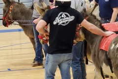 Person holding large fish in gymnasium — donkey basketball fundraiser January 2020