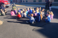 Children in blue uniforms gathered outdoors — fire prevention October 2024