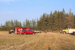 Red harvester in grain field — County Road 11 wildland fire 2023