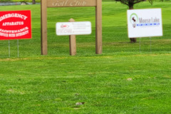 Sponsor signs on green lawn — golf scramble fundraiser September 2025